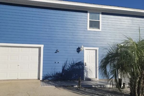 Blue exterior siding with fresh white trim after professional painting