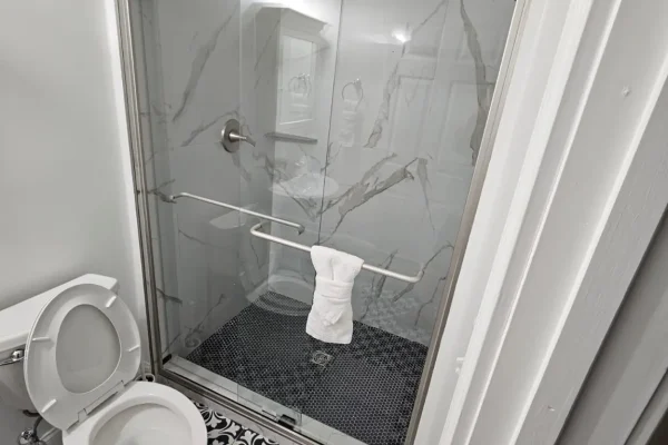 Completed marble-look tile shower remodel with built-in niche
